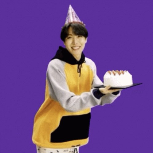 a man dressed as a cat holding a cake