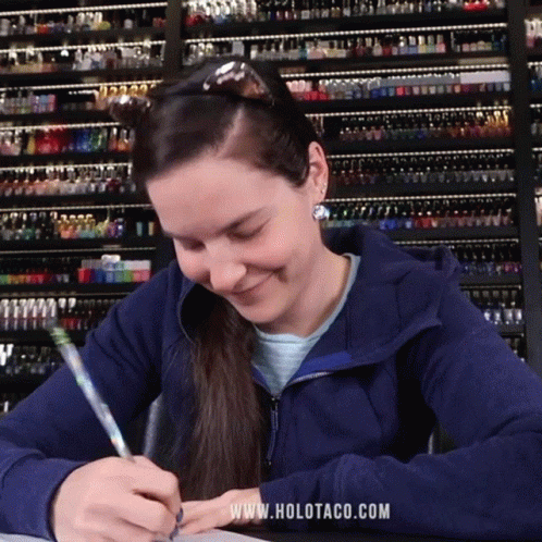 a person with long hair writing at a table