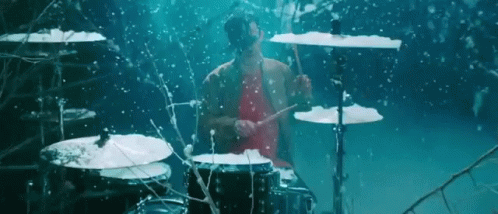 drummer playing on the beat drum with his hands and drums in front of him