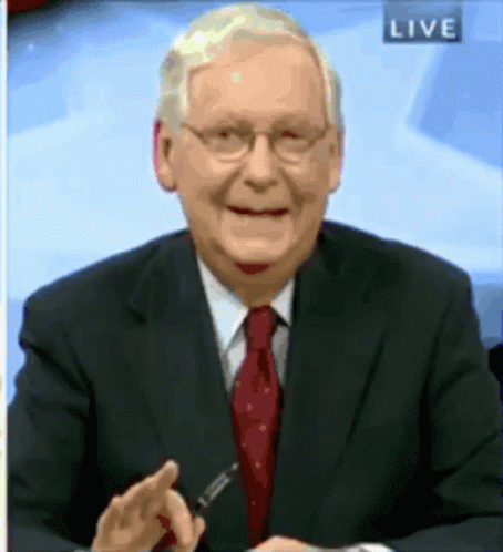 an old man with glasses is sitting down on a news desk