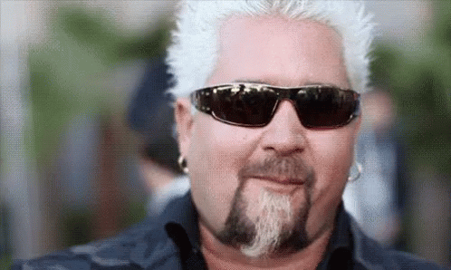 a man with a blue beard and white hair wearing black sunglasses