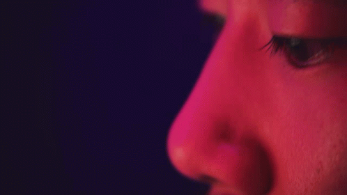 a close up of a face with purple light