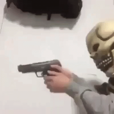 a skeleton holding a gun next to a wall