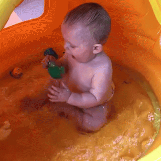 a baby is playing in a tub with the toys