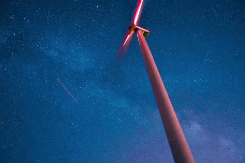 two large windmills are standing against a brown sky