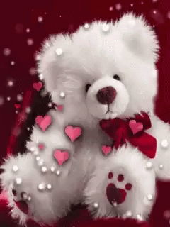 a white teddy bear with hearts on it