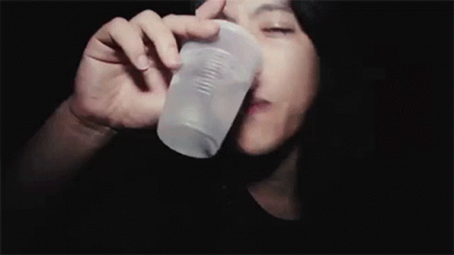 a woman holding up her head to the side as she drinks out of a bottle