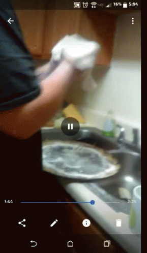 a person holding soing in one hand near a sink