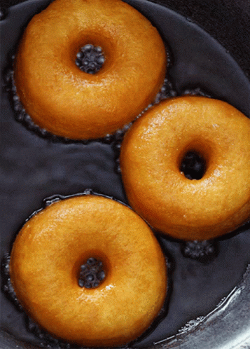 blue donuts in a silver pan next to water