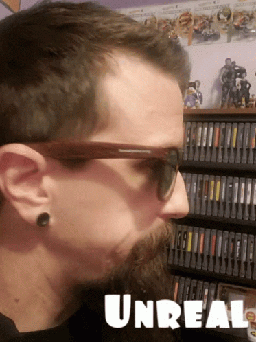 there is a man that has his face slightly open and a video game behind him