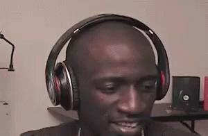 a man wearing headphones looking down at his cell phone