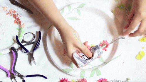 a pair of blue gloves are being used to make flower and scissors