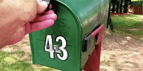 a person's hand is opening the mailbox