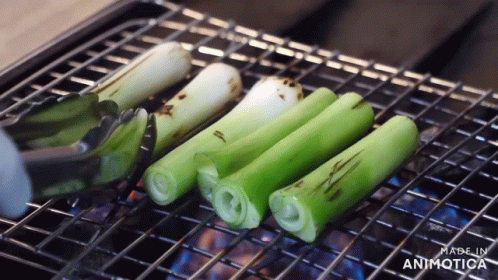 green and black items being cooked on a grill