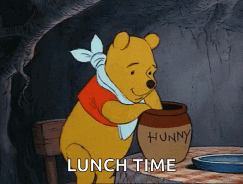 the pooh bear sitting at a table is holding up the food dish