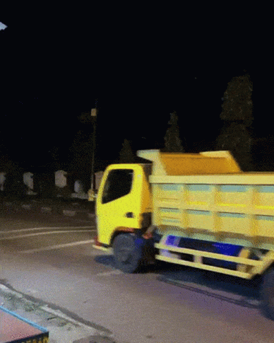 this is a blue garbage truck driving down the road