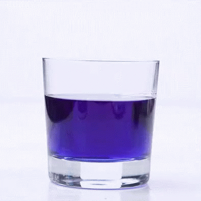 a half filled glass with purple liquid in it