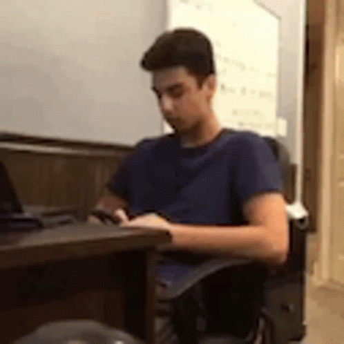 a boy using his laptop in an office