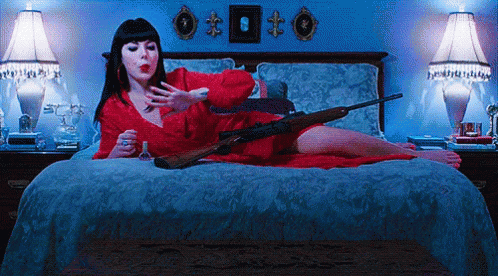 a woman laying on top of a bed with a guitar