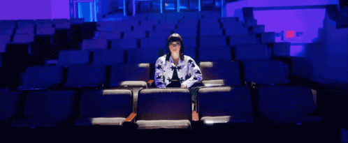 a woman is sitting alone in a theatre