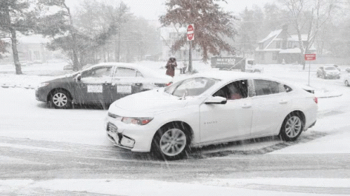 a white car parked next to another car in the snow