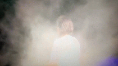 a blurry po of a person standing on the ground in smoke