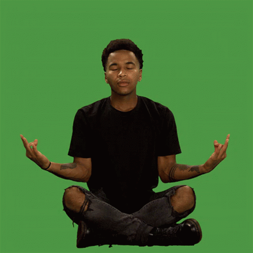 a young man sitting in the middle of a yoga pose