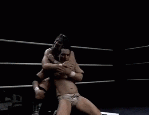 two wrestlers in a wrestling ring hugging