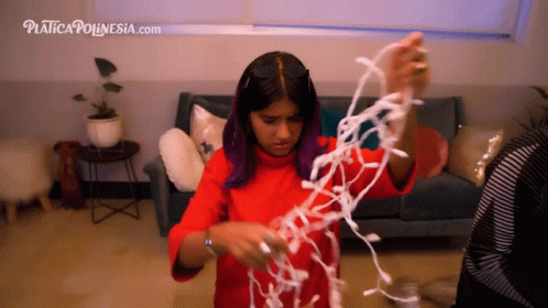 a girl is playing with white stringing in the living room