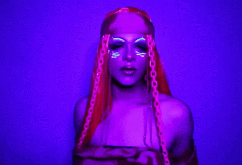 an attractive woman with purple hair and glowing makeup