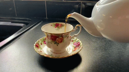 a tea pot and china cup are sitting on the counter