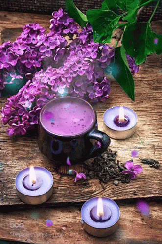 a group of candles sitting in front of a vase filled with flowers