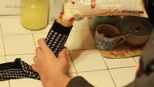 two persons preparing food in the kitchen one holding the glove with its fingers