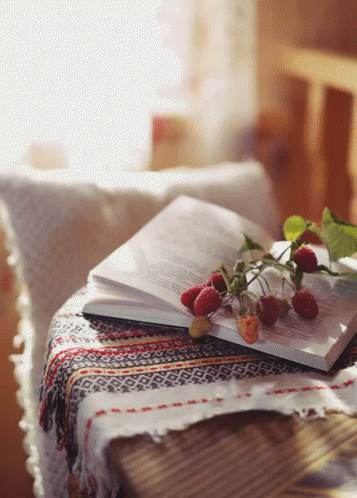 an open book on top of a table with flowers