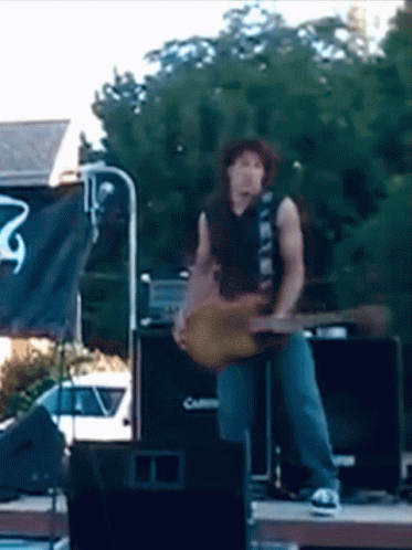 a male guitarist on stage with an american flag