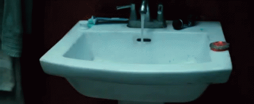a white porcelain sink with a toilette and a blue wall