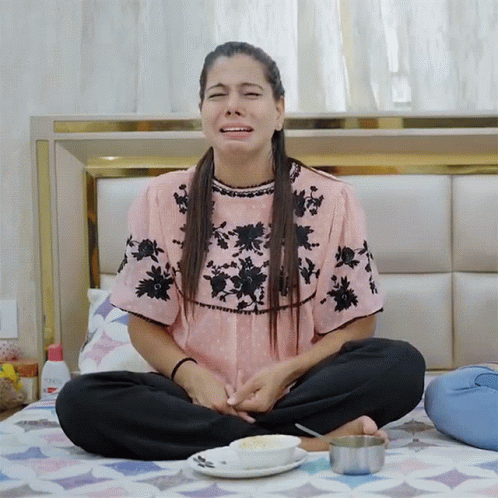 a girl is meditating with her head down while on the bed