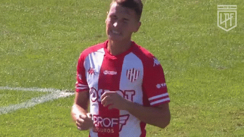 a soccer player holding a ball while on the field