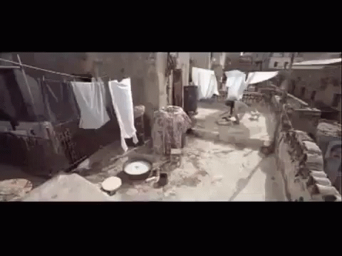 an old slum with some clothes hanging and a dirty floor