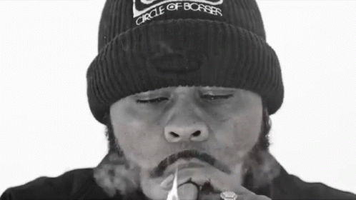 a person smoking a cigarette and wearing a beanie