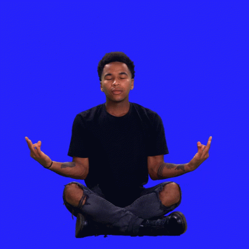 a man sitting in lotus position with his hands outstretched