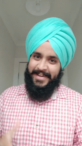 a man in a turban holding his thumbs up