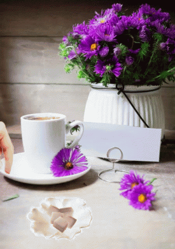 a plate, flowers, and a tea pot on a table