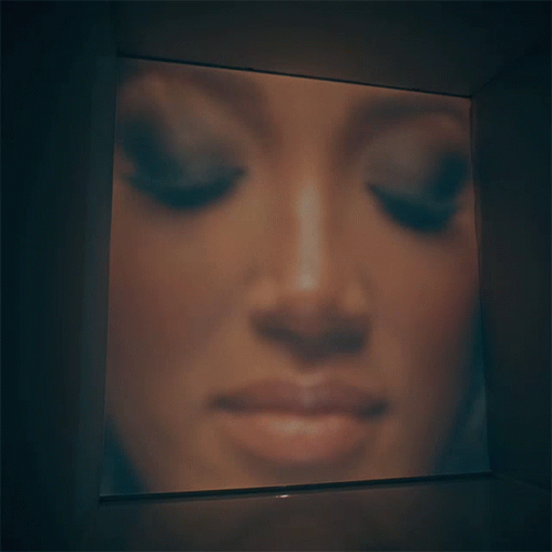 a woman's face is illuminated in a television screen