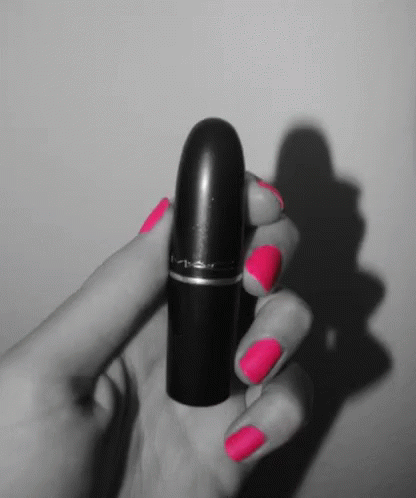 a lady holding onto a black and purple lipstick