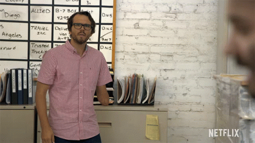 man standing in front of office in front of board with writing on it