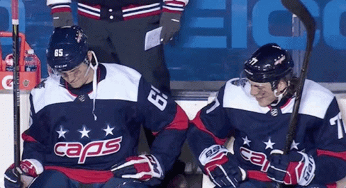 a pair of ice hockey players on bench sitting