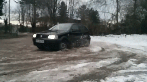 an suv with its headlights off driving through snow
