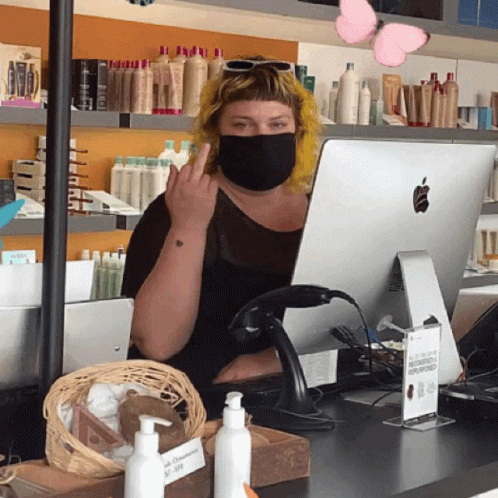 a woman is on the phone with her face covered by a surgical mask