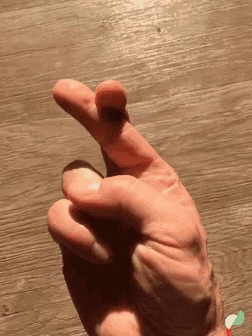 the hand is holding an object up on a table